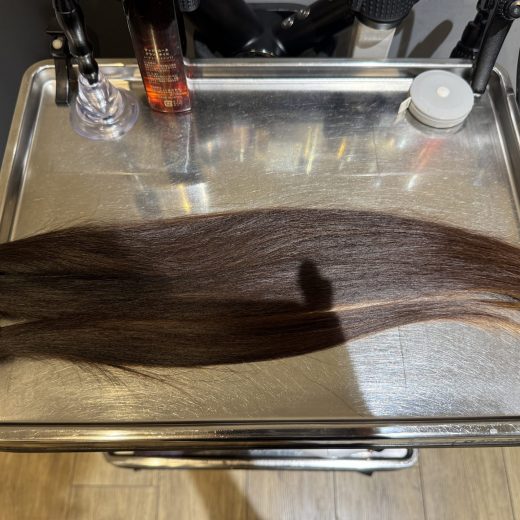 「カット後に並べられた30cm以上のヘアドネーション用の毛束」