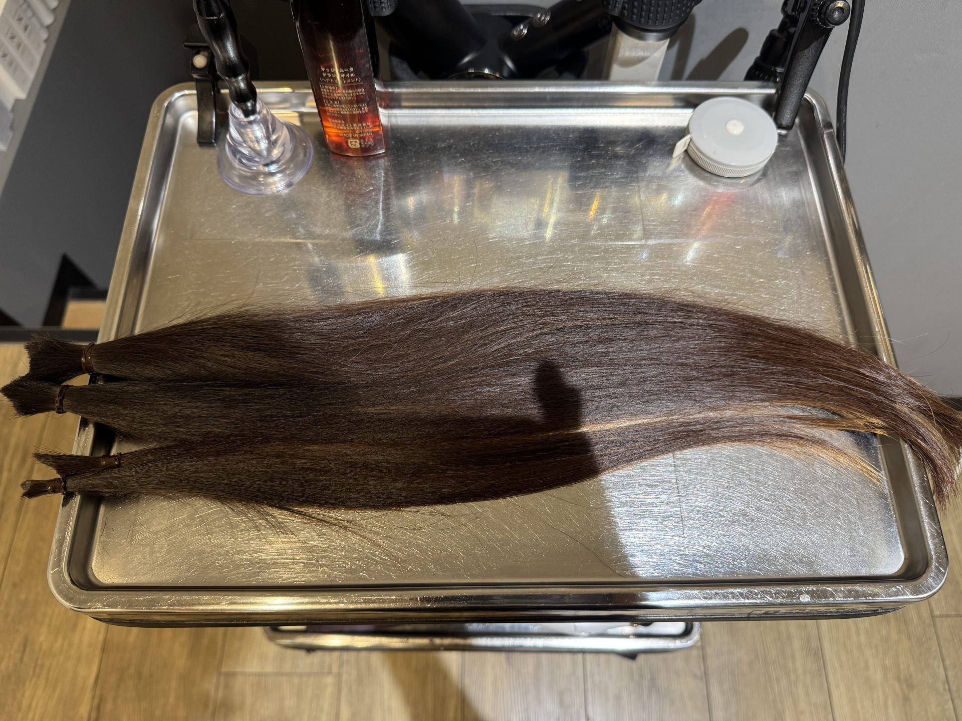 「カット後に並べられた30cm以上のヘアドネーション用の毛束」